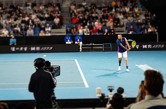 Nick Kyrgios stojący dwa metry za linią końcową z przygotowanym backhandem