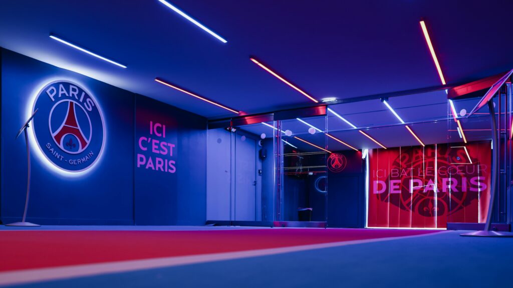 Korytarz stadionowy Paris Saint-Germain, oświetlony niebieskimi i czerwonymi światłami LED.
