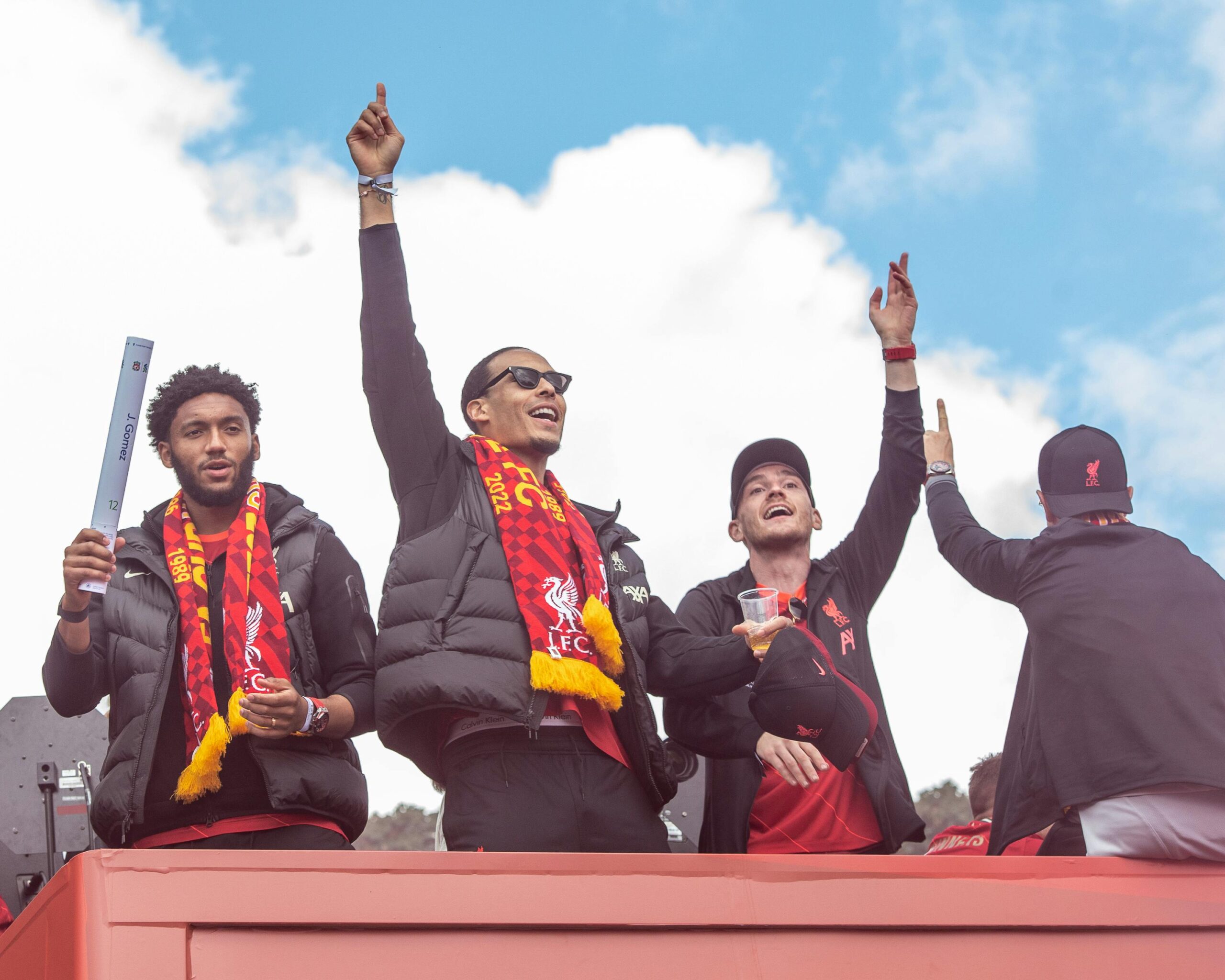 Joe Gomez, Virgil Van Dijk i Alexis Mac Allister świętują triumf na szycie autobusu