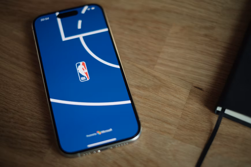 Telefon z wyświetlonym logo NBA na drewnianym stole
