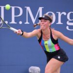 Magdalena Fręch wyciąga rakietę do przodu, aby odegrać rywalce