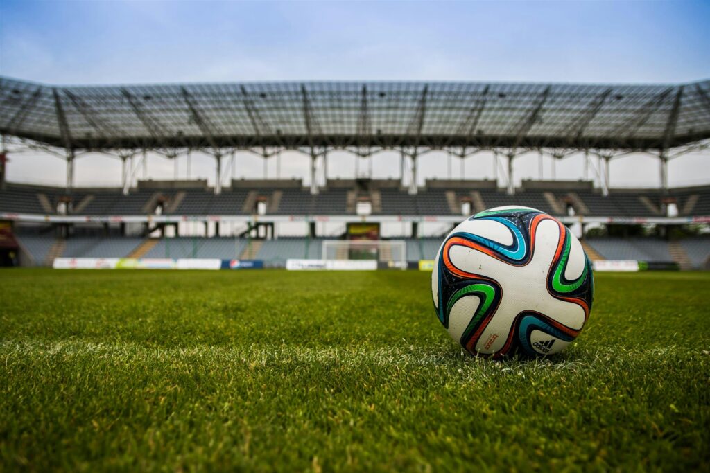 Zbliżenie na piłkę do piłki nożnej, umieszczonej na trawie stadionu