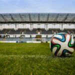 Zbliżenie na piłkę do piłki nożnej, umieszczonej na trawie stadionu