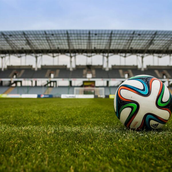 Zbliżenie na piłkę do piłki nożnej, umieszczonej na trawie stadionu