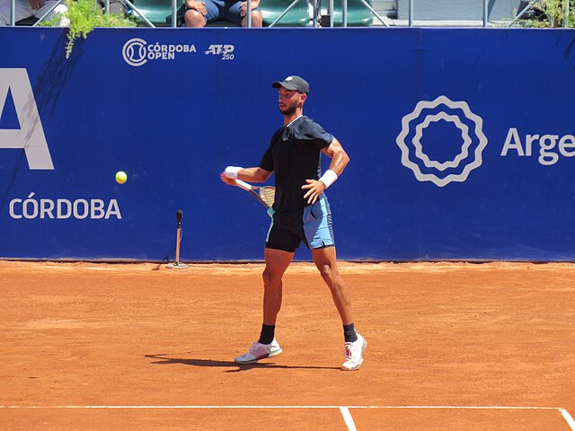 Thiago Agustin Tirante na linii końcowej uderza piłkę forehnadem