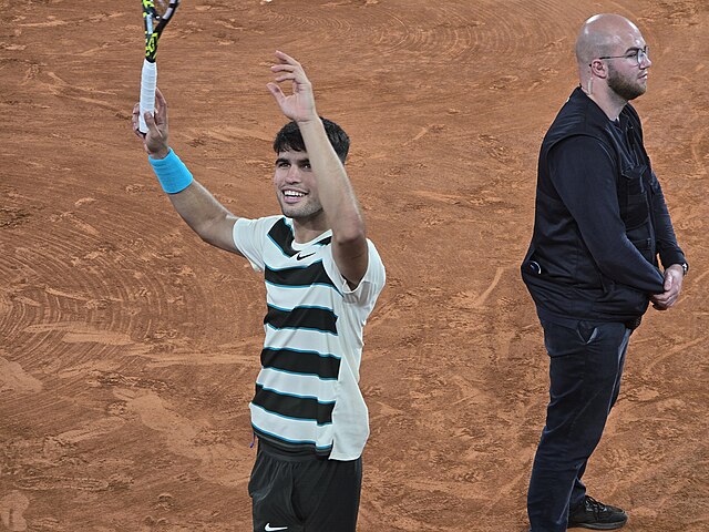 Carlos Alcaraz wznosi ręce w po zwycięstwie