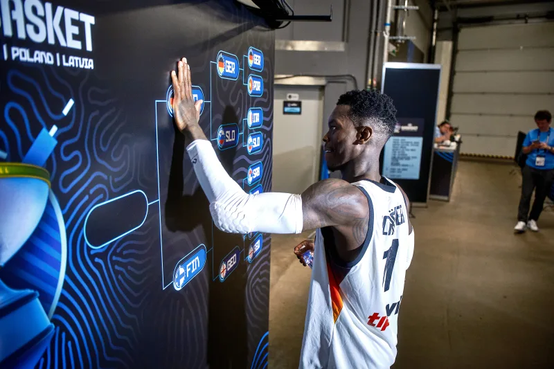Dennis Schroder przystawia dłoń przy drabince turniejowej EuroBasketu