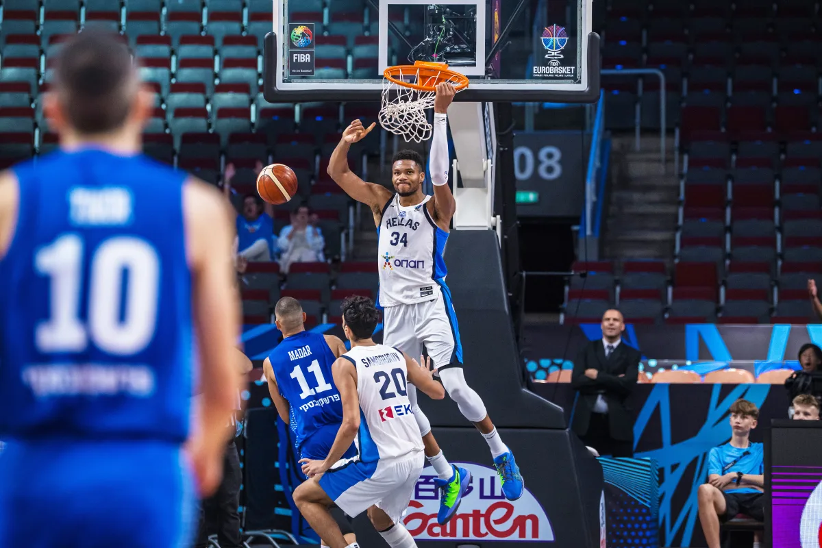 Giannis Antetokounmpo zwisający na jednej ręce po zrobieniu wsada