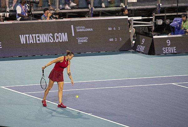 Aryna Sabalenka kozłująca piłkę tenisową na linii końcowej