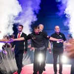 Krzysztof Ratajski wchodząc na scenę wita się z fanami