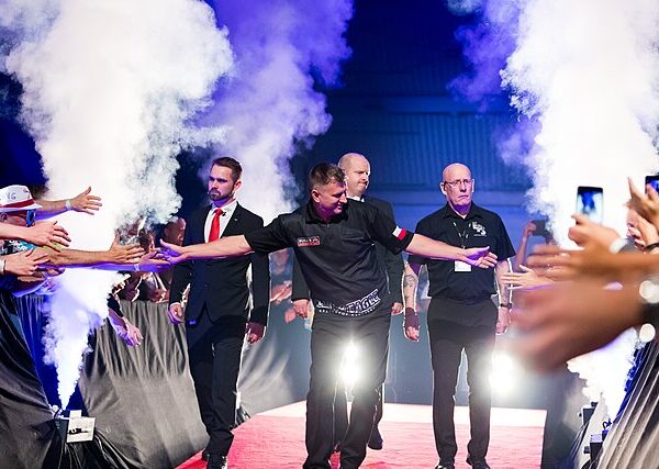 Krzysztof Ratajski wchodząc na scenę wita się z fanami