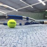 Główka rakiety oparta o piłkę tenisową