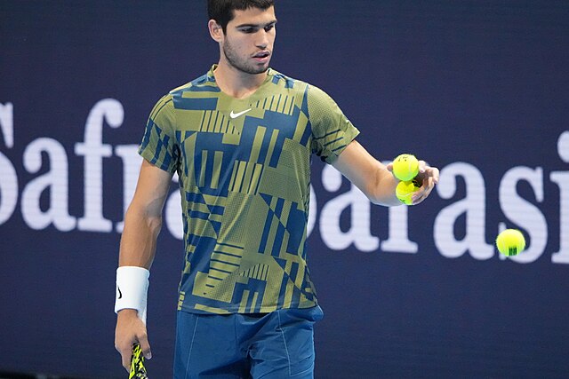 Carlos Alcaraz z piłką tenisową w ręce przed oddaniem serwisu