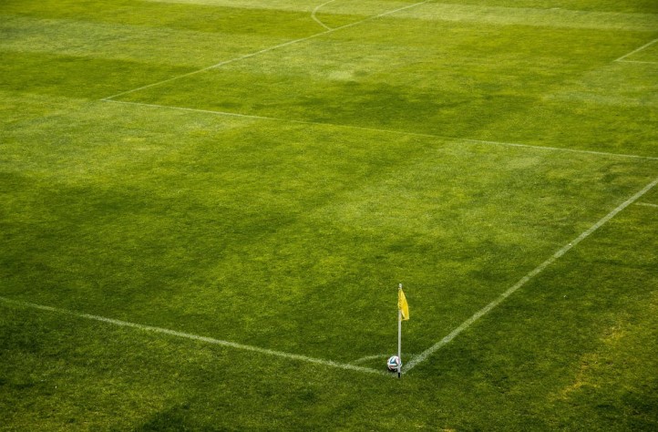 Ujęcie z trybun przedstawiające piłkę ustawioną na rogu boiska