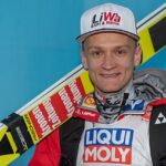 Daniel Huber z nartami na ramieniu