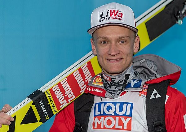 Daniel Huber z nartami na ramieniu