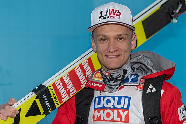 Daniel Huber z nartami na ramieniu