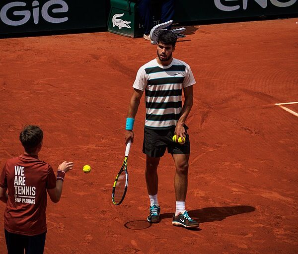 Carlos Alcaraz odgrywający piłkę ballboyowi