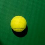 Piłka tenisowa w cieniu rakiety