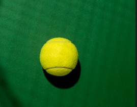 Piłka tenisowa w cieniu rakiety