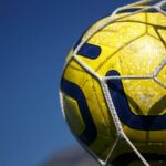 Żółta piłka w siatce na tle nieba