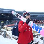 Dawid Kubacki z nartami opartymi o ramię