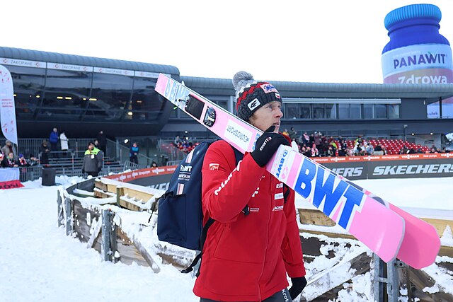 Dawid Kubacki z nartami opartymi o ramię