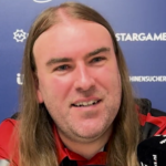 Twarz Ryana Searla na tle ścianki medialnej