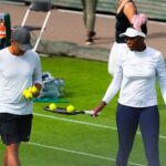 Venus Williams z wystawioną rakietą odbiera piłki tenisowe od trenera podczas treningu