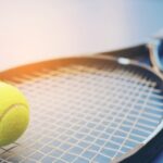 Rakieta tenisowa z piłką na boisku