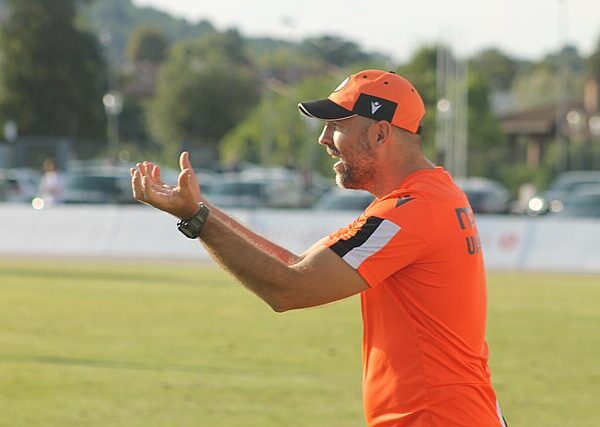 Iogr Tudor w pomarańczowych barwach energicznie gestykuluje