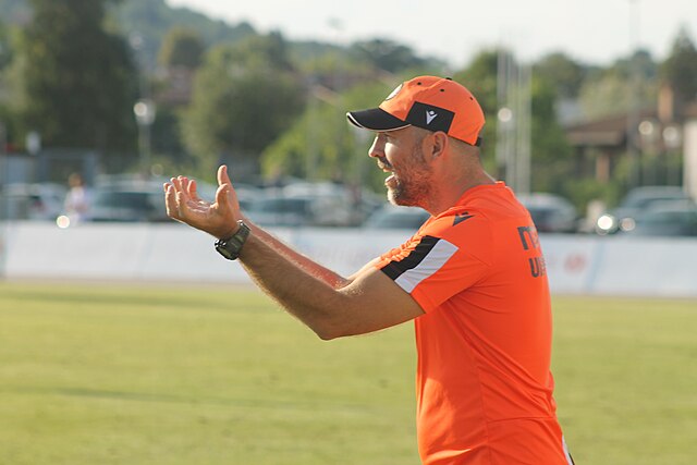 Iogr Tudor w pomarańczowych barwach energicznie gestykuluje