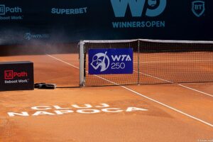 Kawałek siatki na korcie ziemnym, na którym widnieje napis WTA 250
