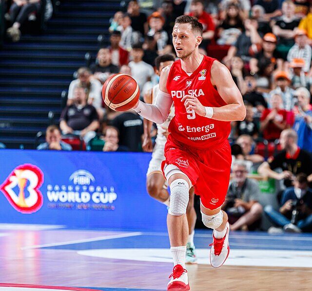 Mateusz Ponitka kozłujący piłkę na wysokości połowy boiska