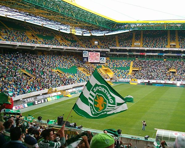 Flaga Sportingu Lizbona na tle pełnego stadionu kibiców