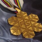 Złoty medal w kształcie śnieżynki z logiem FIS