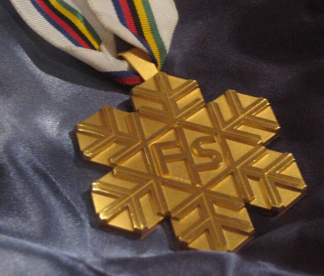 Złoty medal w kształcie śnieżynki z logiem FIS