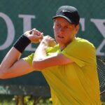 Jannik Sinner trzymający rakietę za plecami