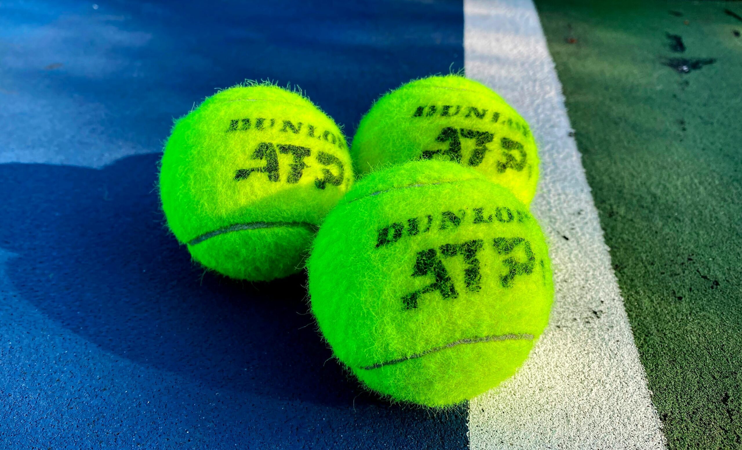 Zbliżenie na trzy piłki tenisowe z napisem ATP