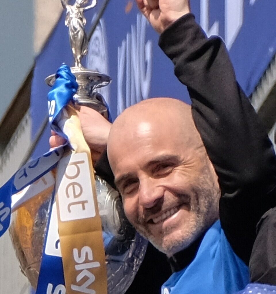 Enzo Maresca wznoszący puchar Ligi Konferencji w szaliku Chelsea
