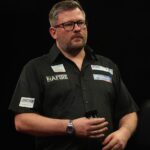 James Wade trzymający lotki na wysokości brzucha