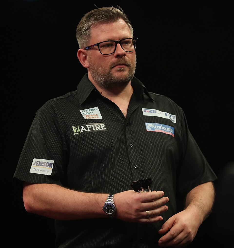 James Wade trzymający lotki na wysokości brzucha