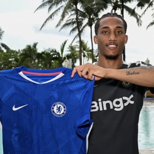 Joao Pedro trzyma koszulkę Chelsea na tle palm