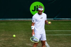 Alejandro Davidovich Fokina z piłką tenisową i rakietą w rękach