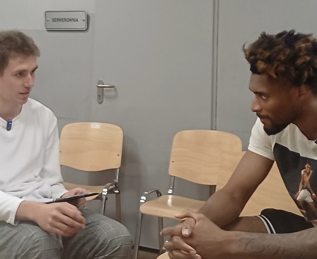 Jalen Thomas na przeciwko Dawida Kwiatkowskiego siedzący na krzesłach