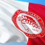 Logo Olympiakosu na biało-czerwonej fladze