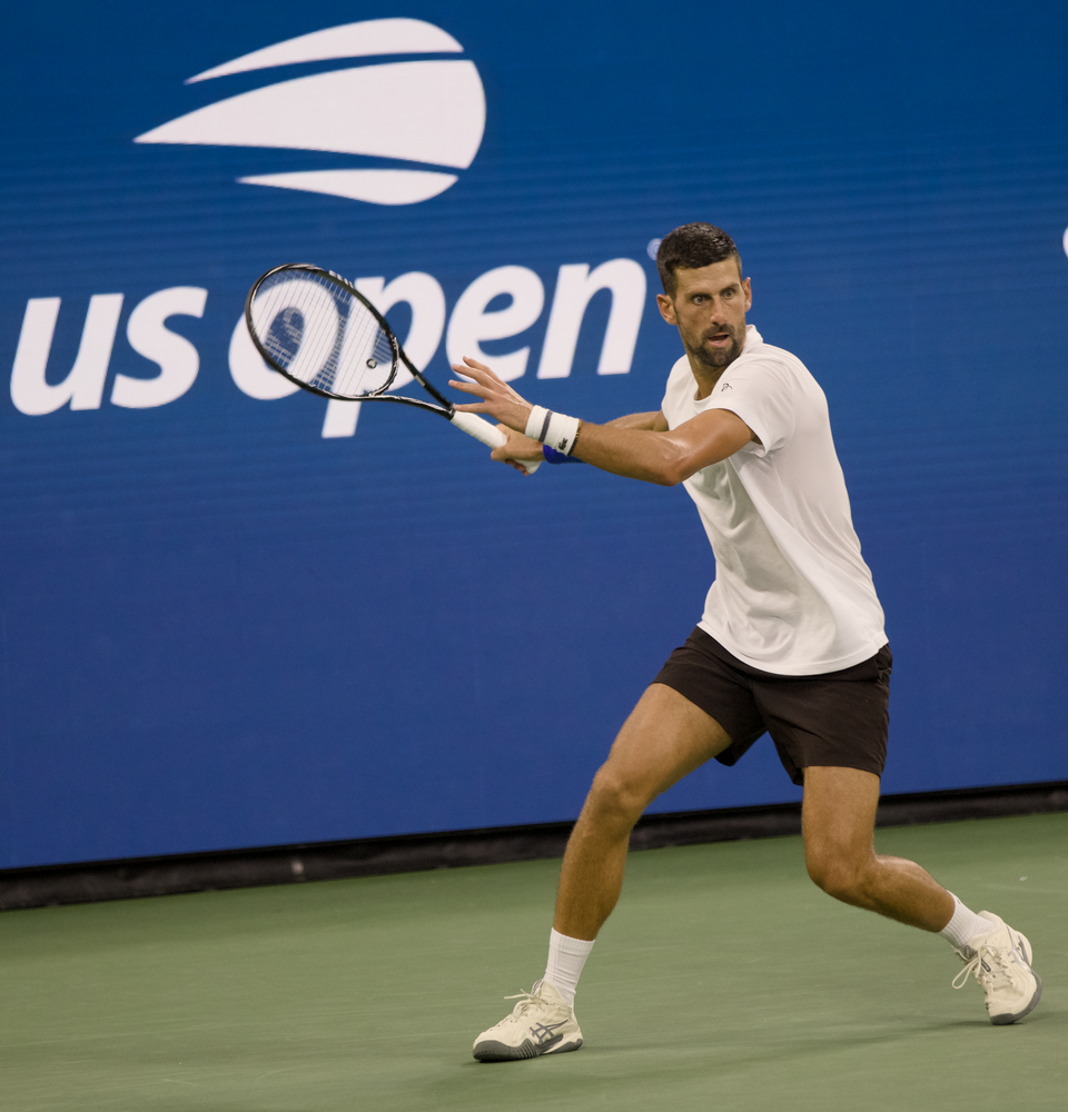 Novak Djoković pod bandą reklamową przymierza się do forehandu